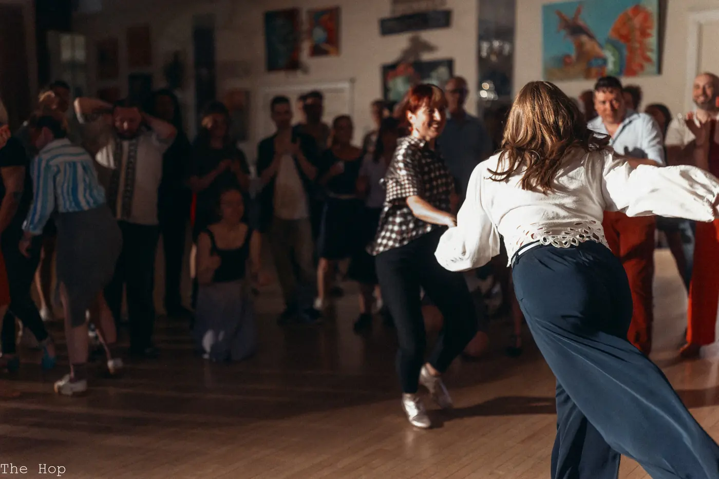 A dancer in a white blouse spinning across the floor